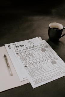 black ceramic mug beside white printer paper by Kelly Sikkema courtesy of Unsplash.